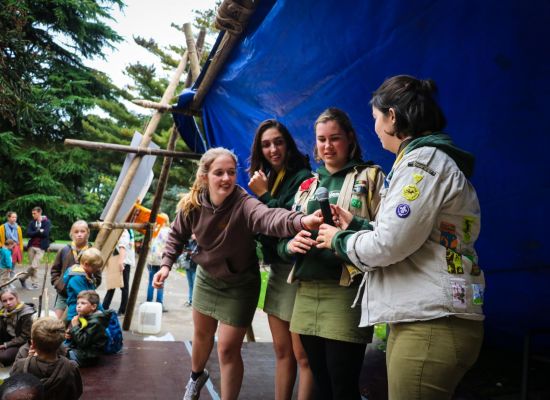 leidsters op podium geven micro door aan elkaar