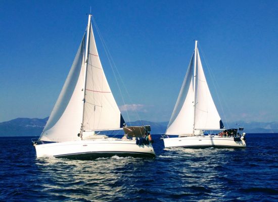 Twee zeilboten op het water.