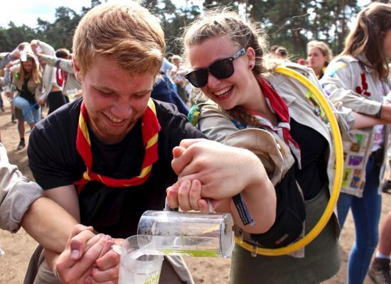 Leider en leidster spelen een spel met water doorgeven op Herfstontmoeting