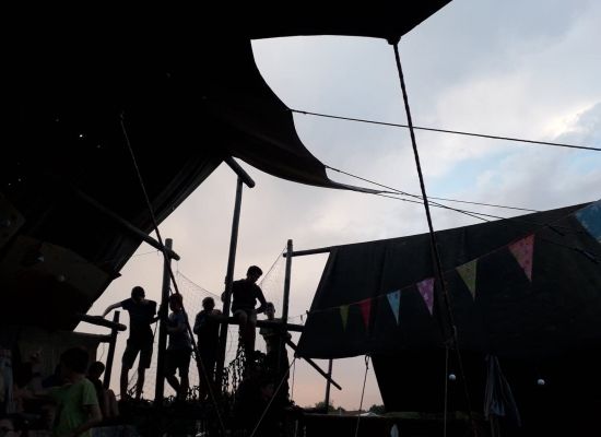Kinderen die in de hoogte zitten, waar hun tenten staan en het versierd is met vlaggetjes