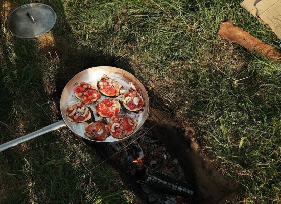 Pan met lekkere zelfgemaakte mini pizzaatjes op houtvuur.