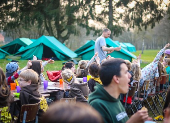 Kinderen aan tafel met tenten op de achtergrond