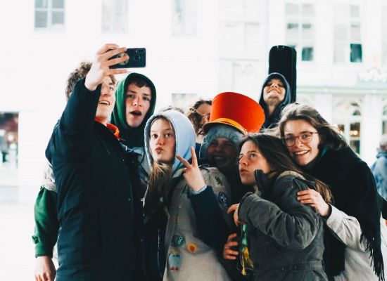 scouts en gidsen met hoodies en jassen aanposeren voor een selfie