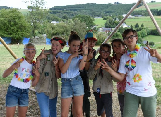 Een groepje jonggivers op kamp verkleed als hippies