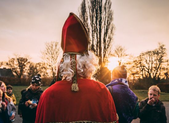 Sonterklaas en Zwarte piet op bezoek bij een groepje snoepende leden.