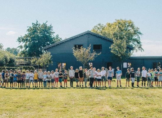 scoutsgroep staat in een rij voor hun lokaal