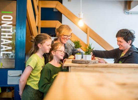 Onthaalmedewerker ontvangt een gezin op jeugdverblijf de brink