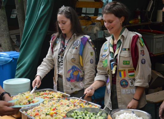 Leiding schept eten op op kamp