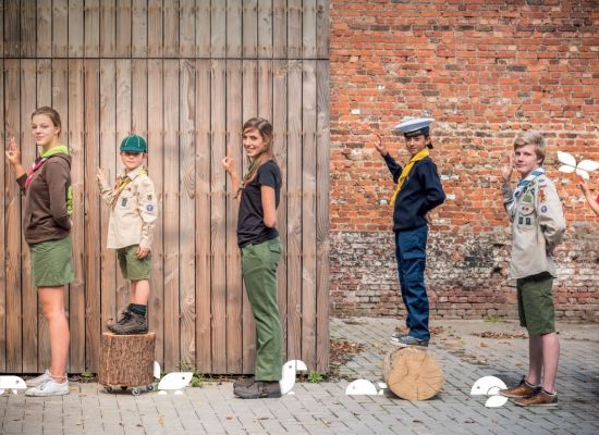 verschillende scoutsuniformen op een rij