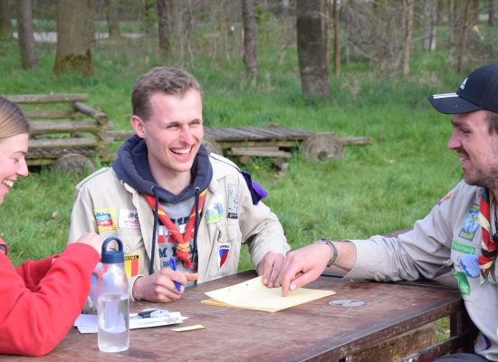 Drie leiding rond een tafel lachen