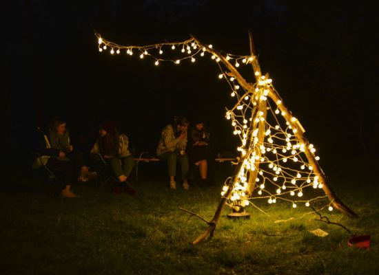 Structuurvrijwilligers rond een "kampvuur" van lichtjes