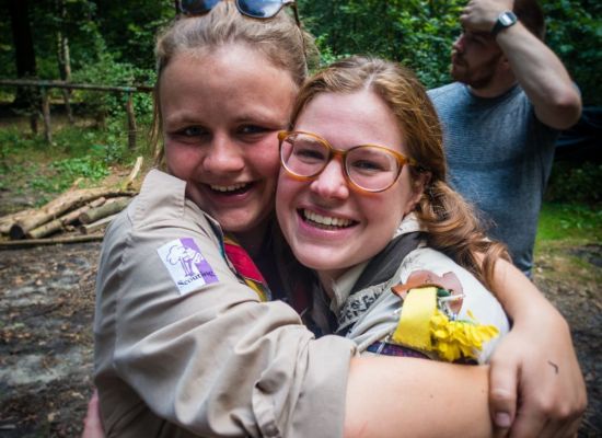 Twee structuurvrijwilligers knuffelen