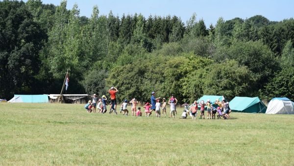 Groep leden zitten in een rking op hun kampterrein